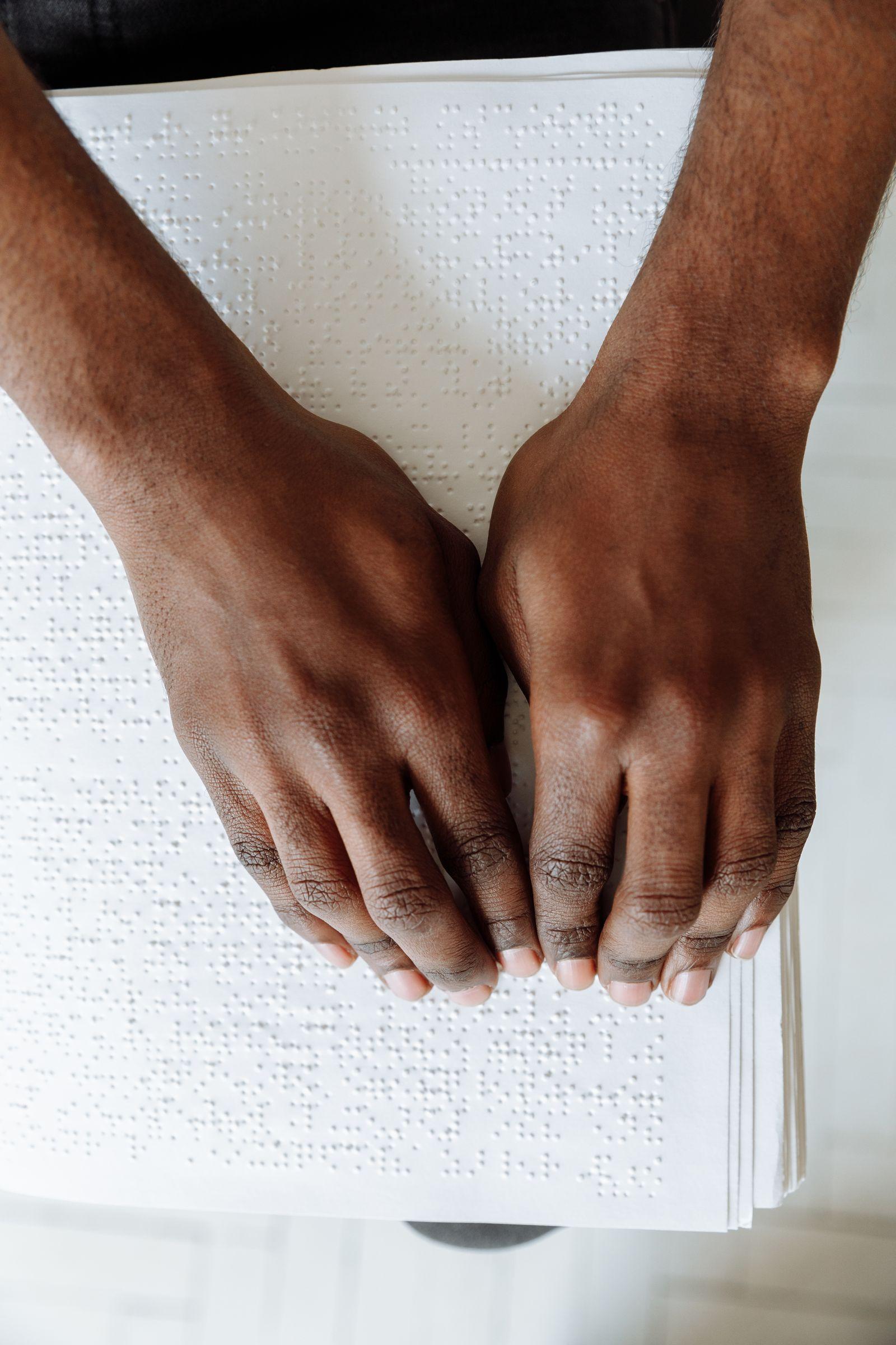 Hands reading a braille document