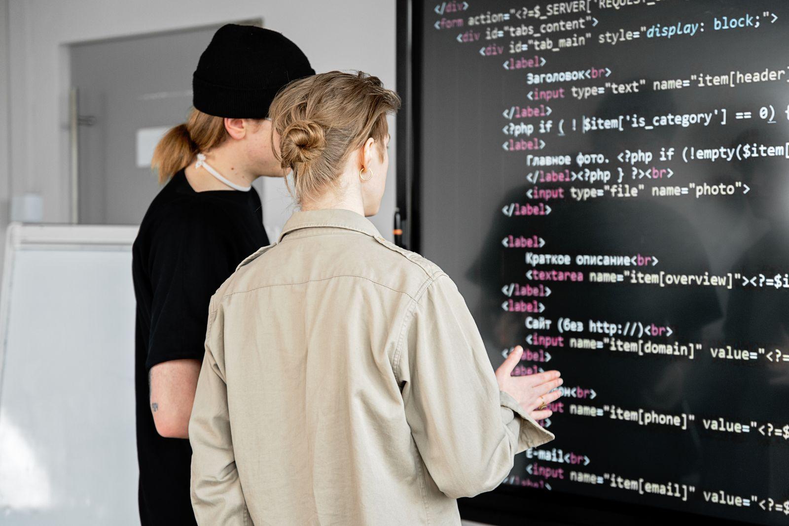 Developers reviewing localized application code together on a large screen